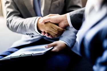 A lawyer in Orlando, FL and his client doing a handshake after a successful small business case.